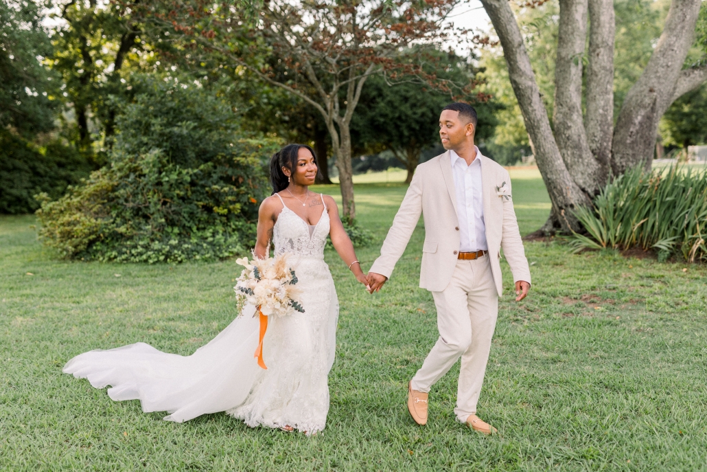 Newlyweds holding hands walking outdoors