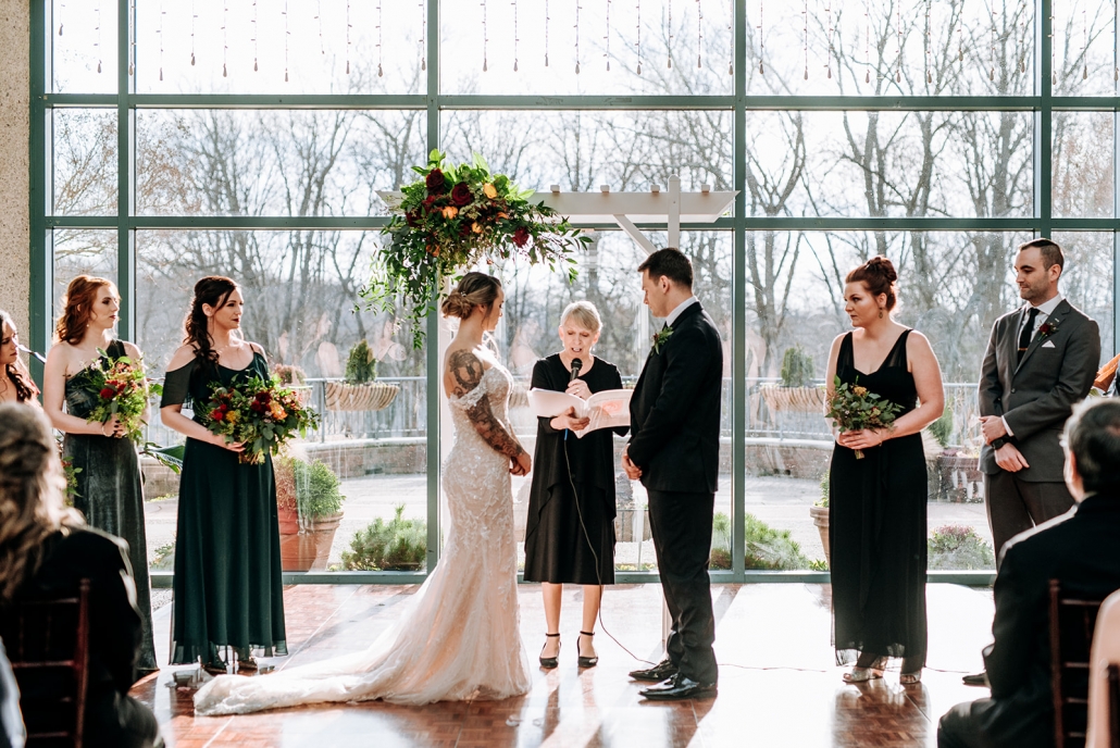 Bride and groom standing at the alter with officiant and wedding party