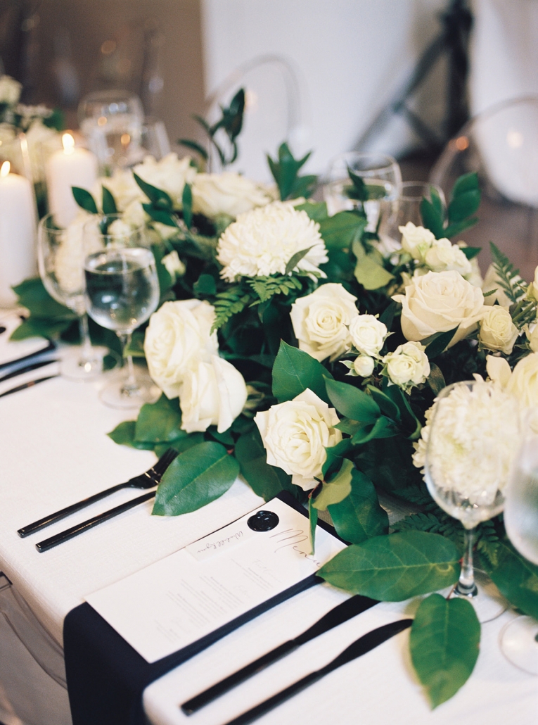 Classic white and black place setting with florals and menu